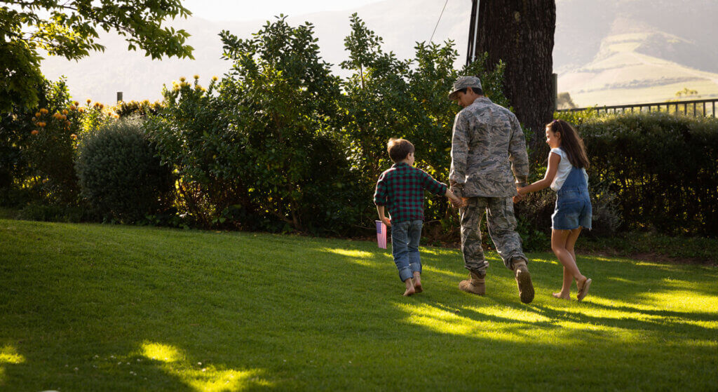 A military family enjoying time together in the backyard of their new home